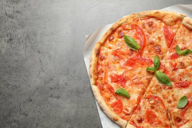 Gri masadaki Margherita pizzası harika görünüyor. Metin için boşluk