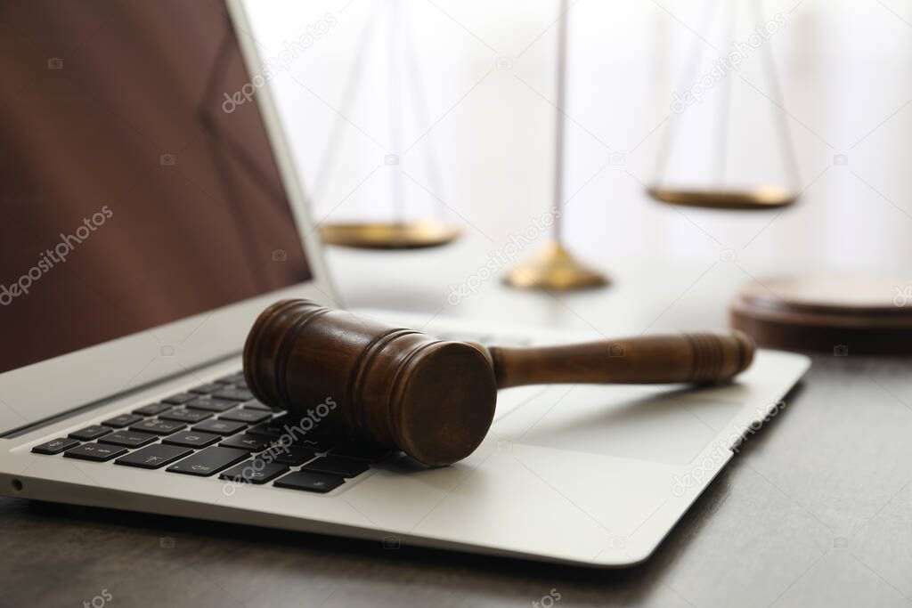 Laptop, gavel and scales on table, closeup. Cyber crime