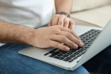 Evdeki modern dizüstü bilgisayarda çalışan adam, yakın plan