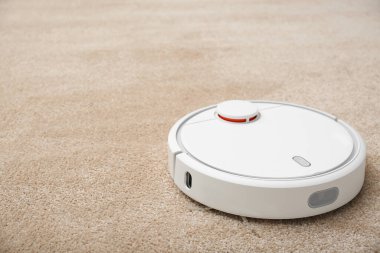 Modern elektrikli süpürgeyle halıdaki toprağı temizliyorum. Metin için boşluk