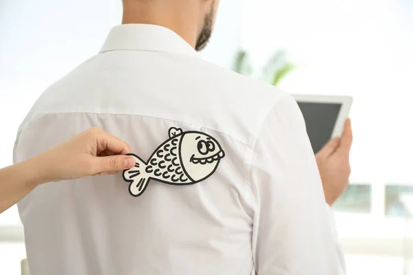 Frau Klebt Papierfisch Auf Den Rücken Des Kollegen Büro Nahaufnahme — Stockfoto