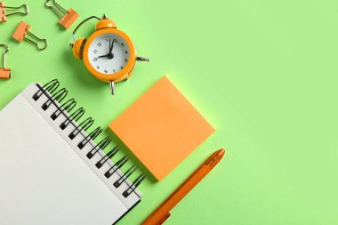 Açık yeşil arka planda modern turuncu ofis aksesuarları düz yatıyordu.