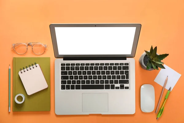 橙色背景的笔记本电脑和办公文具 — 图库照片