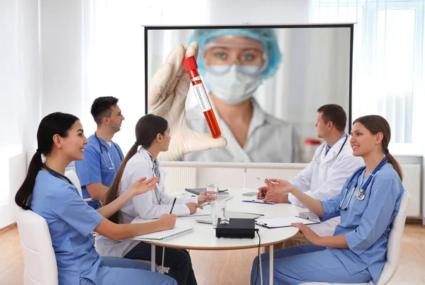 事務所でのコロナウイルス会議中にビデオプロジェクターを使用して医師のチーム — ストック写真