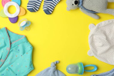 Sarı zemin üzerinde çocuk kıyafetleri ve aksesuarları ile düz kompozisyon, metin için boşluk