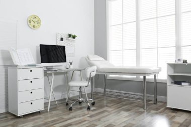 Bilgisayar ve muayene masası olan modern tıp bürosu.