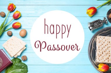 Açık mavi ahşap masa üzerinde sembolik Pesach (Hamursuz Bayramı Seder) öğeleri ile düz kompozisyon yatıyordu