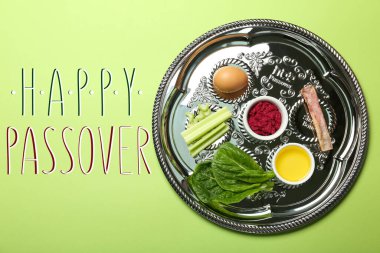 Yeşil arka planda sembolik yemeği olan Hamursuz Bayramı yemeği tabağı (keara), üst manzara. Pesah kutlaması