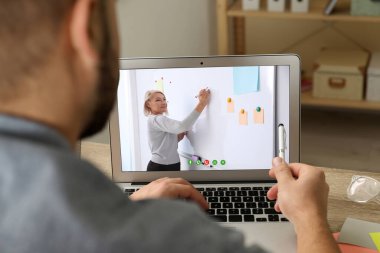 Masada video izleyen genç adam, yakın plan. Çevrim içi öğrenim