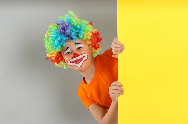 十几岁的男孩 头戴小丑假发 从黄色横幅向外张望 背景浅灰色 文字空间 四月愚人节 — 图库照片