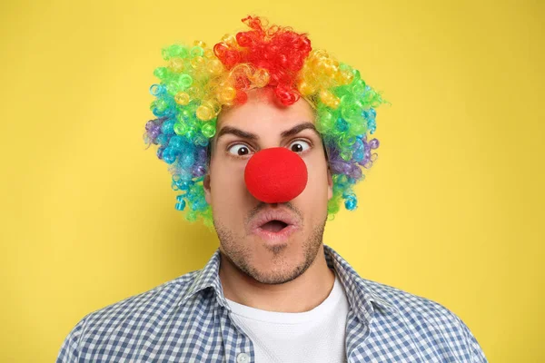 滑稽的男人 长着小丑鼻子和黄色背景的彩虹假发 四月愚人节 — 图库照片