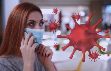 Koronavirüs salgını sırasında maskeli bir kadın evde telefonla konuşuyor.