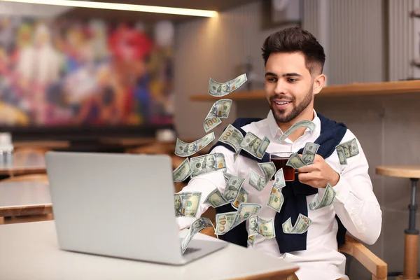 현대적 랩탑을 남자와 실내에서 지폐를 날리는 사람들은 온라인으로 법니다 — 스톡 사진