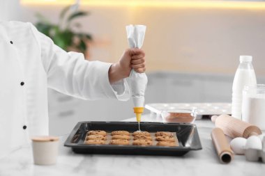 Kadın aşçı mutfak masasında bisküvi hazırlıyor, yakın plan. Lezzetli yemekler pişiriyorum.