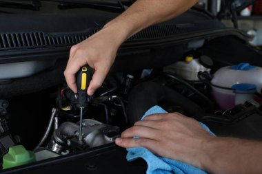 Profesyonel oto tamircisi servis merkezinde modern arabayı tamir ediyor.