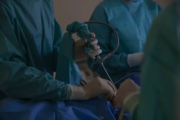 Team of professional doctors performing operation in surgery room