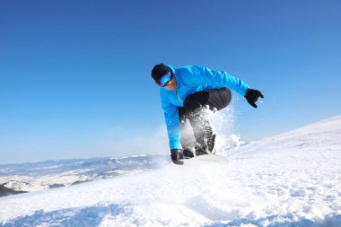 Snowboard yapan adam karlı tepede. Kış tatili