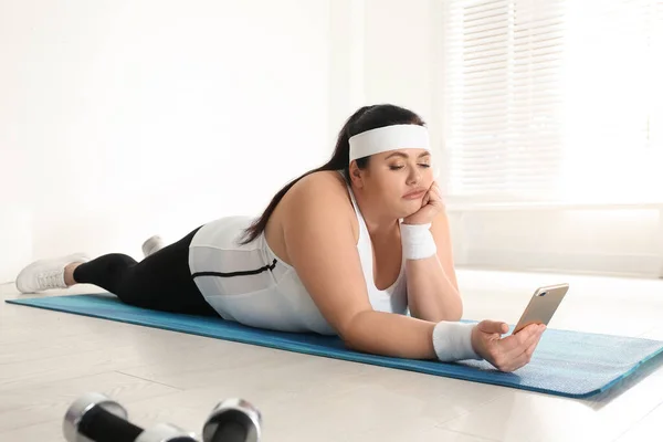 懒惰的超重女人用手机而不是在健身房锻炼 — 图库照片