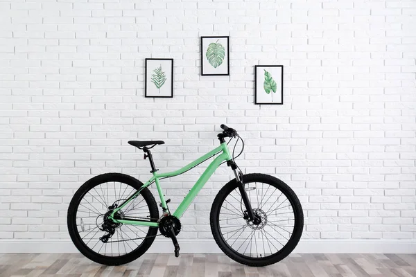 Современный Зеленый Велосипед Возле Стены Белого Кирпича Помещении — стоковое фото