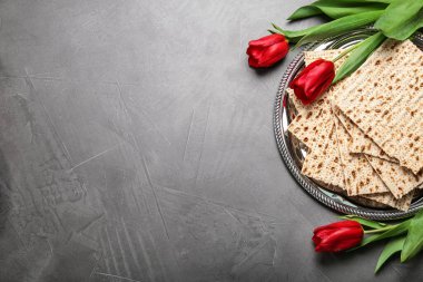 Gri masada geleneksel Pesach (Hamursuz Bayramı) matzasıyla düz kompozisyon. Metin için boşluk
