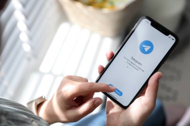 MYKOLAIV, UKRAINE - 16 Mart 2020: Kapalı alanda Telegram uygulamalı iPhone 11 'i tutan kadın, yakın plan
