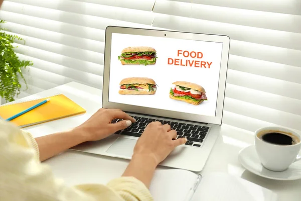 Woman using laptop for online food order during quarantine, closeup. Delivery service