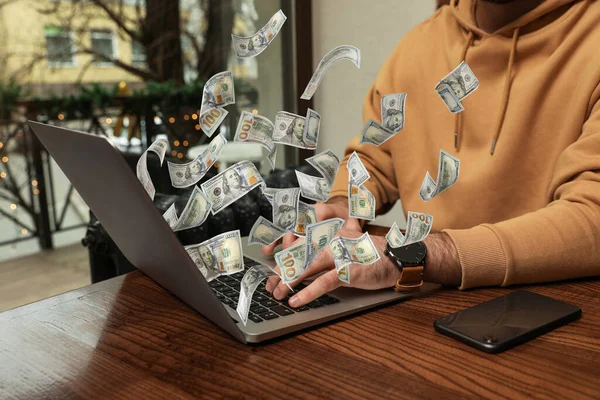Человек Современным Ноутбуком Летающими Долларовыми Банкнотами Столом Помещении Крупным Планом — стоковое фото