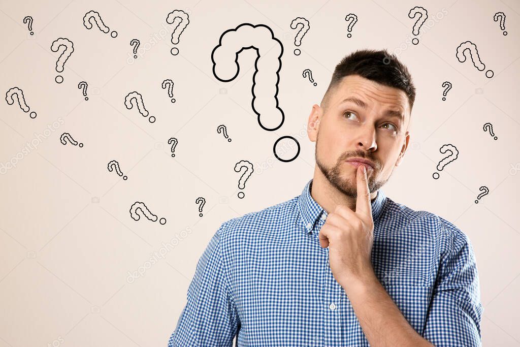 Emotional man with drawings of question marks on white background