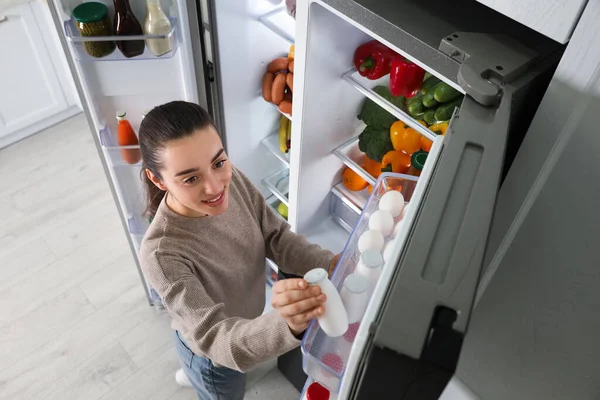 Mujer Joven Tomando Yogur Del Refrigerador Interior Vista Superior — Foto de Stock