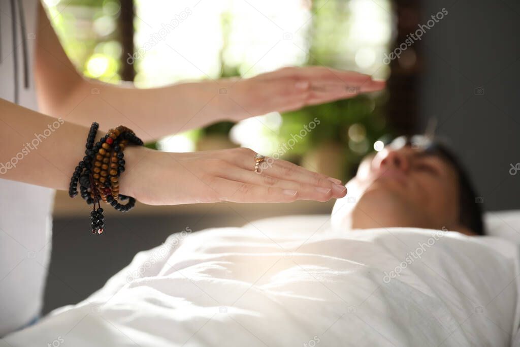 Man during crystal healing session in therapy room