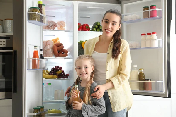 Jovem Mãe Com Filha Perto Refrigerador Aberto Cozinha — Fotografia de Stock