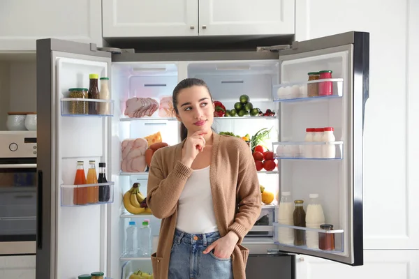 Jovem Mulher Atenciosa Perto Refrigerador Aberto Cozinha — Fotografia de Stock