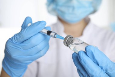 Şırıngayı ilaçla dolduran doktor, yakın çekim. Aşılama ve aşılama