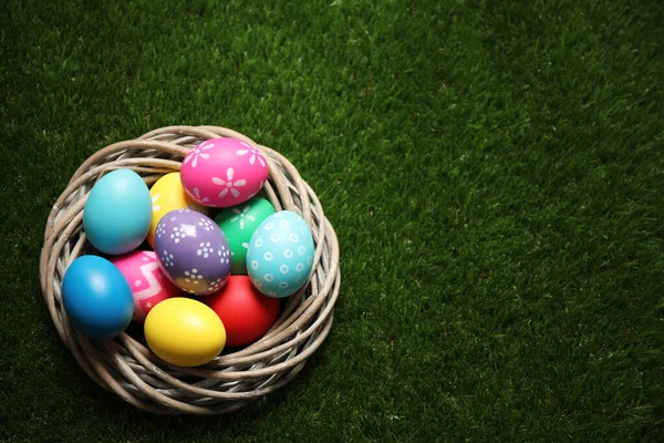Yeşil Çimlerin Üzerindeki Dekoratif Yuvada Renkli Paskalya Yumurtaları Üst Manzara — Stok fotoğraf