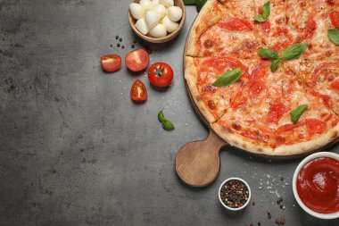 Lezzetli pizza Margherita ve gri masa üzerindeki malzemeler. Metin için boşluk