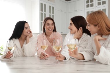 Mutfakta şarap kadehleri olan güzel genç bayanlar. Kadınlar Günü