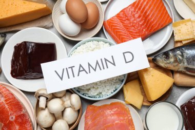 Deyimi VITAMIN D olan kağıt ve masa üzerinde taze ürünler, düz yatıyordu