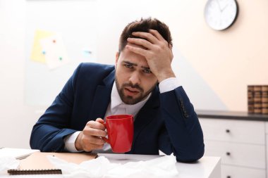 İş yerindeki hasta genç adam. Grip virüsü