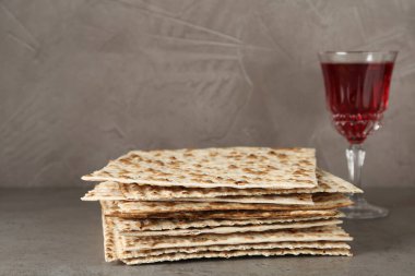 Hamursuz bayramı matzoları ve gri masada bir bardak şarap. Pesach kutlaması