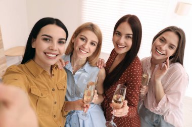 Şampanya içen güzel genç bayanlar evde selfie çekiyorlar. Kadınlar Günü
