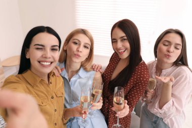 Şampanya içen güzel genç bayanlar evde selfie çekiyorlar. Kadınlar Günü