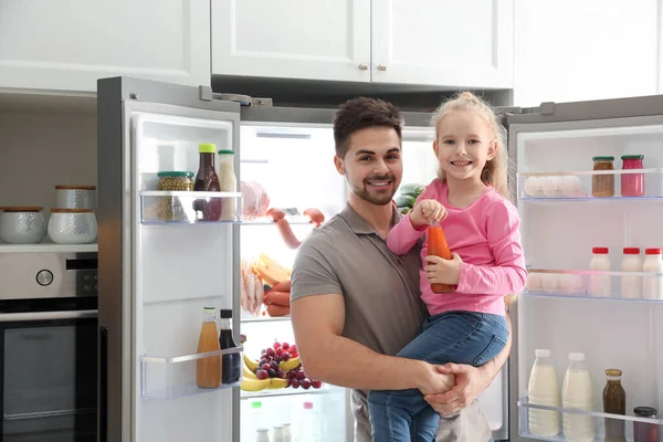 年轻的父亲 女儿在厨房开着的冰箱旁 — 图库照片