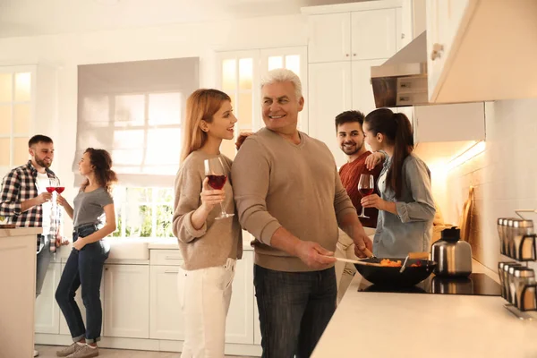 Happy people cooking food together in kitchen