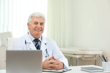 İş yerinde beyaz önlüklü kıdemli doktorun portresi.