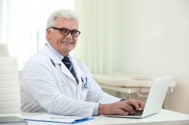İş yerinde beyaz önlüklü kıdemli doktorun portresi.