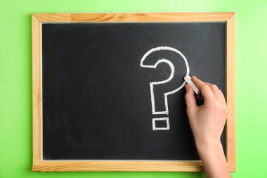 Tahtaya tebeşirle soru işareti çizen kadının üst görünümü, yakın plan