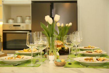 Mutfakta çiçeklerle süslü Paskalya sofrası.