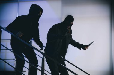 Maskeli adamlar, içeride merdivenlerde bıçaklı. Tehlikeli suçlular.