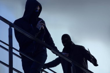 Maskeli adamlar, içeride merdivenlerde bıçaklı. Tehlikeli suçlular.