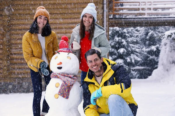 Щасливі Друзі Сніговиком Свіжому Повітрі Сніжний День Зимові Канікули — стокове фото